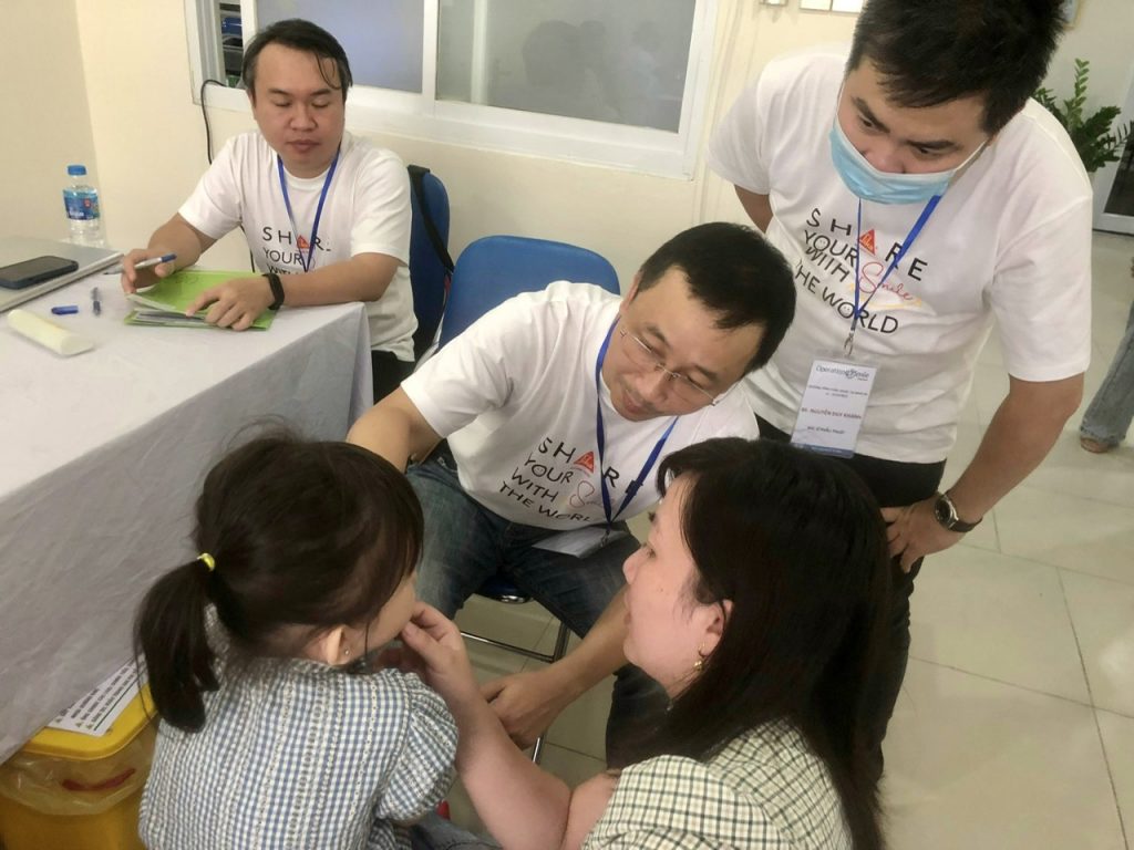 Bác sĩ Lê Thừa Trung Hậu, Trưởng đoàn phẫu thuật Operation Smile, đang khám một bệnh nhân trẻ em